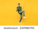 Small photo of Full body side view young happy man he wears green t-shirt casual clothes doing winner gesture celebrate clenching fists say yes raise up hand isolated on plain yellow background. Lifestyle concept