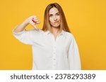 Young dissatisfied displeased upset sad caucasian woman she wears white shirt casual clothes showing thumb down dislike gesture isolated on plain yellow background studio portrait. Lifestyle concept