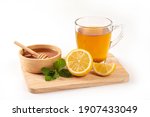 Glass cup of tea with honey , lemon and mint on white background.