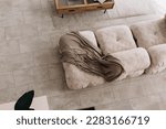 Small photo of Interior design of harmonized living room with design beige sofa carpet, coffee table. Beige floor. Minimalist home decor. Modern concept. above view