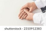 Small photo of doctor's hand holding calms reassuring the patient's hospital. close-up the encouragement trust and medical lessening support carefully. Hands resting on the table with a stethoscope near the doctor.