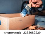 Small photo of The brush applies varnish to furniture. Varnishing furniture with varnish