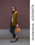 Small photo of perfect spring fashion outfit. european fashion blogger wearing a trendy mustard velvet blazer, black jeans, fishnet stockings and black loafers. holding a stylish handbag.