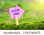 good vibes arrow sign on green moss with sunshine background