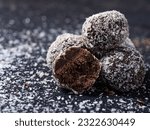 Choco Almond Energy Balls are neatly presented and isolated with a slightly grayish black background.