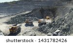 Excavator and heavy mining dump trucks in a limestone quarry, loading of stone ore, industrial panorama.
