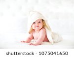 Six month baby wearing towel after bath. Childhood and baby care concept