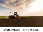 Farmer With Tractor Seeding  ...