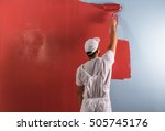 Young Man Painting Wall With...