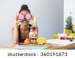 Woman smiling with a tropical fruit salad, being playful covering her eyes with dragon fruit