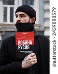 Small photo of Ukrainian activist posing with a book "damned russians" on a public protest against russian invasion in Ukraine. Kyiv - 17 March,2024