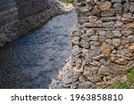 Small photo of Bridge abutment with gabions. Gabion wall constructed using steel wire mesh basket. Stone walls, protection from backshore erosion. Gabion and rock armour - coastal and waterways protection.