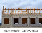 Construction of wooden frame of roof. Building construction, roof rafters installation. Install ridge board and rafter, house under construction. Timber frame roof structure
