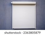 Rolling shutters, window with closed roller shutters. House facade with window on first floor, security and protection concept