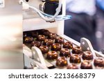 sweets production and industry concept - chocolate candies processing on conveyor at confectionery shop. High quality photo