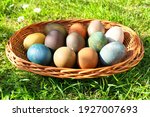 Colorful Easter eggs in the basket on green grass. Natural dyed Easter eggs.