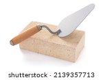 Brick and trowel tool isolated on white background. Construction brick with mason at white