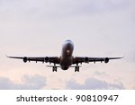 Commercial airplane with four engines in final approach front view