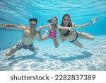 underwater photo of big  family with little kids  swimming  in pool