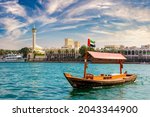 Abra - old traditional wooden boat and Al Farooq Mosque on the bay Creek in Dubai, United Arab Emirates