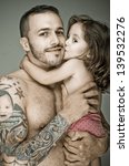 Small photo of Father with tattoos holding his Baby girl, color processed dragan