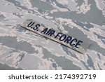 Small photo of US AIR FORCE branch tape on digital tiger-stripe pattern Airman Battle Uniform (ABU) background