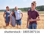 Small photo of Concept of adopted child, boy standing on foreground with adoptive family on background, stepson with father, mother and pre-teen sister