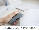 Close-up of man's hand stapling paper in office