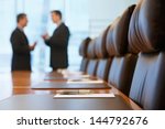 Side view of two blurred businessmen talking in conference room