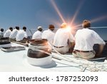 Rear view of sailing crew with lens flare