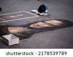 Small photo of Florence, Italy - 09202019: A drawn painting of Mona Lisa on a street floor by an artist in Florence Italy.