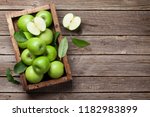 Ripe green apples box on wooden table. Top view with space for your text