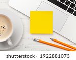 Office desk with yellow sticker, coffee and laptop. Remote office and work from home concept. Top view flat lay with copy space