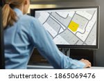 Small photo of woman working with digital cadastral map land register database on computer in office