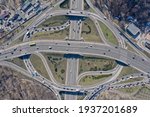 Aerial high drone in flight over evening road traffic. Highway and overpass with cars and trucks, interchange, two-level road junction in the big city. Top view.