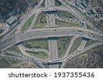 Aerial high drone in flight over evening road traffic. Highway and overpass with cars and trucks, interchange, two-level road junction in the big city. Top view.