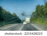 Highway through a broken windshield after encountering a truck with crushed stone. Challenging driving on Asian roads