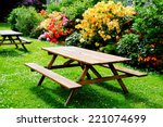 Bbeautiful picnic area with wooden table and blooming rhododendrons
