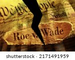 Small photo of Torn Roe V Wade newspaper headline on the US Constitution with the United States Supreme Court in background