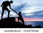 Couple hiking help teamwork and trust silhouette in mountains, sunset and ocean. Male and woman hiker helping each other on top mountain looking at beautiful night landscape motivation and inspiration