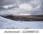 Small photo of Beautiful Winter landscape image from mountain top in Scottish Highlands down towards Rannoch Moor during snow storm and spindrift off mountain top in high winds
