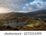 Beautiful Winter sunrise golden hour landscape view from Loughrigg Fell across the countryside in the Lake District