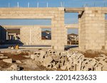 Small photo of Concrete shell of a single-family house under construction, with framed views of houses nearer to completion, in a suburban development on a sunny afternoon in southwest Florida