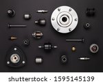 Studio photography - a lot of automotive parts: valves, spark plugs, silent blocks, thermostats,  sensors, wheel hub, bearings, lie in straight rows on a flat surface isolated on a black background.
