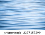 Blue water surface with a pattern of soft waves, background photo texture