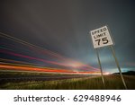 75np speed limit sign at night next to afreeway at night