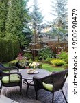 Small photo of Beautifully landscaped Canadian backyard with a perennial flowers and evergreen trees. Outdoor seating in a garden surrounded by a cedar fence in Canada. Also available in horizontal.