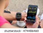 Female Runner Looking At Her Mobile And Smart Watch Heart Rate Monitor