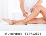 Close-up Of A Beautician Waxing Woman's Leg In Beauty Spa