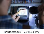Person's Finger Pointing To Electric Meter Reading Using Flash Light